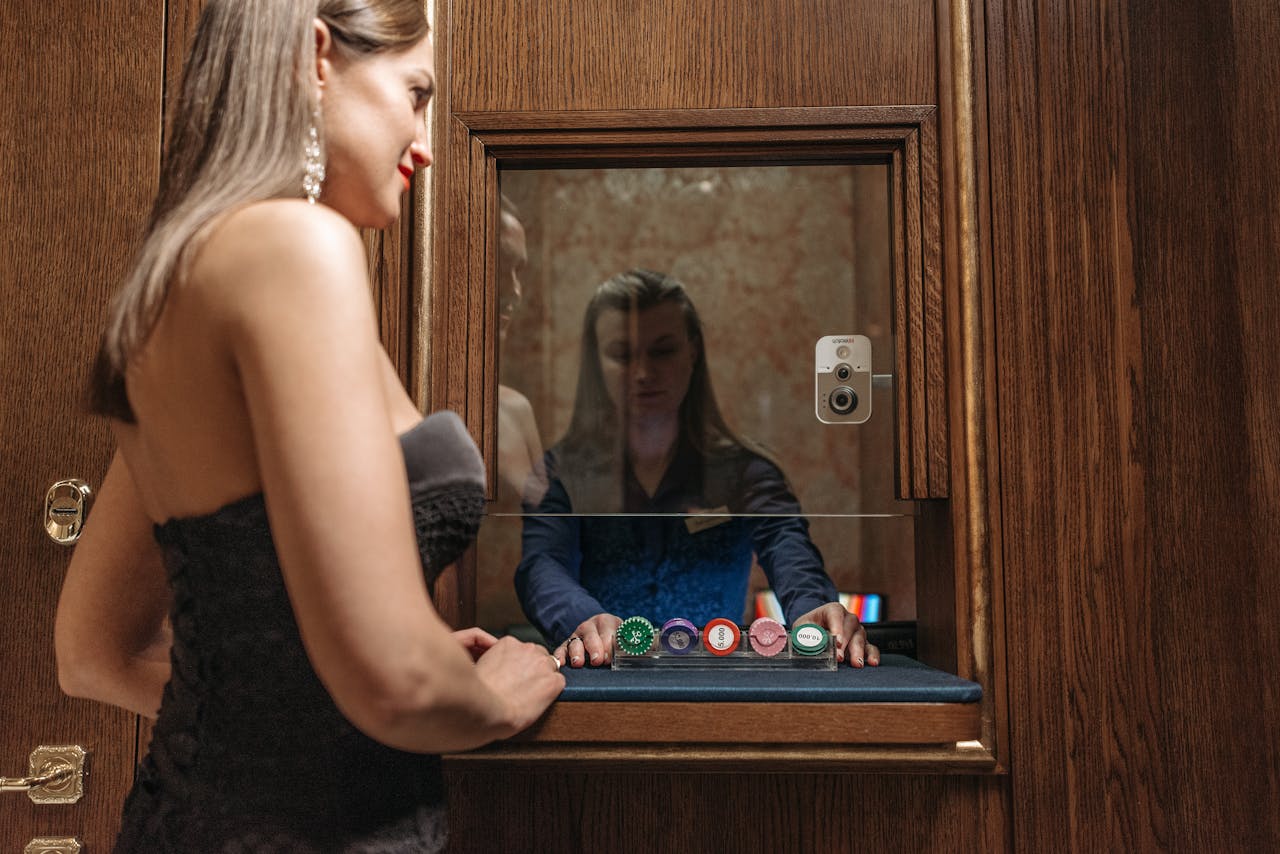 A woman at a casino desk receiving chips from a cashier, highlighting glamour and gambling.